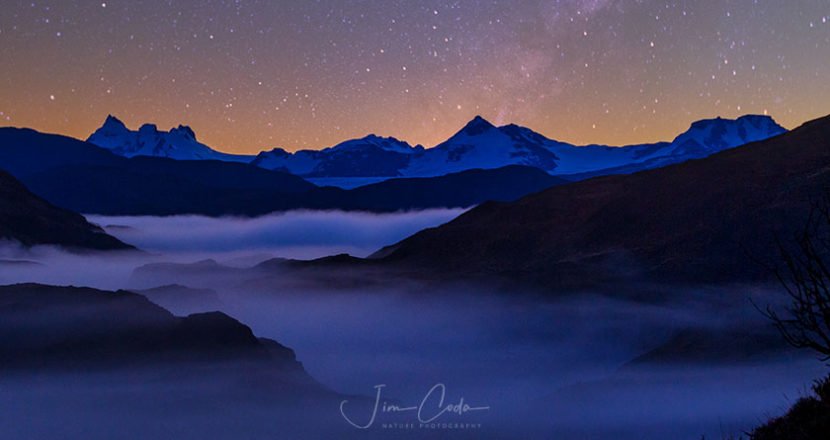 Photo of some mountain peaks and fog at dawn in Torres del Paine National Park