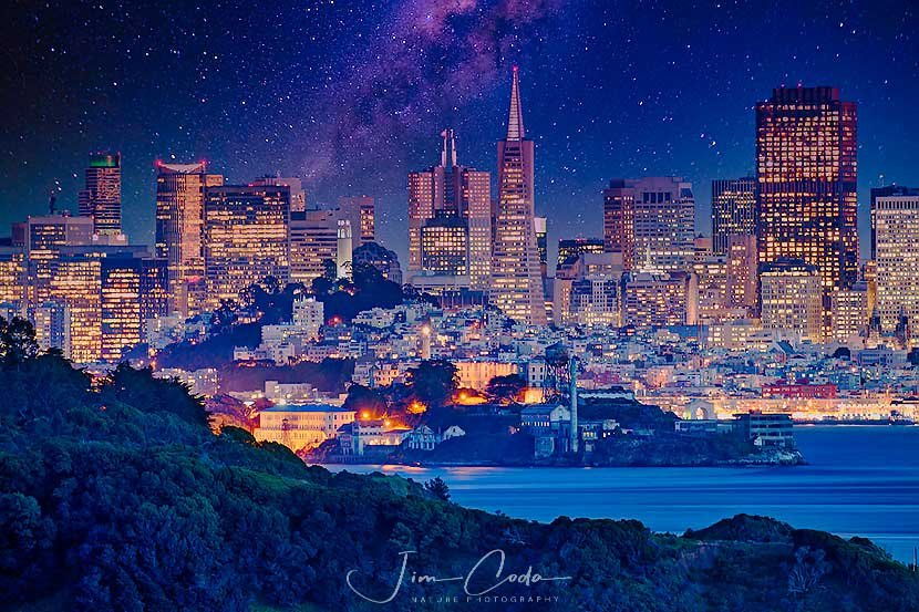 This is a night photo of the San Francisco skyline with Angel Island in the foreground and Alcatraz in the midground.