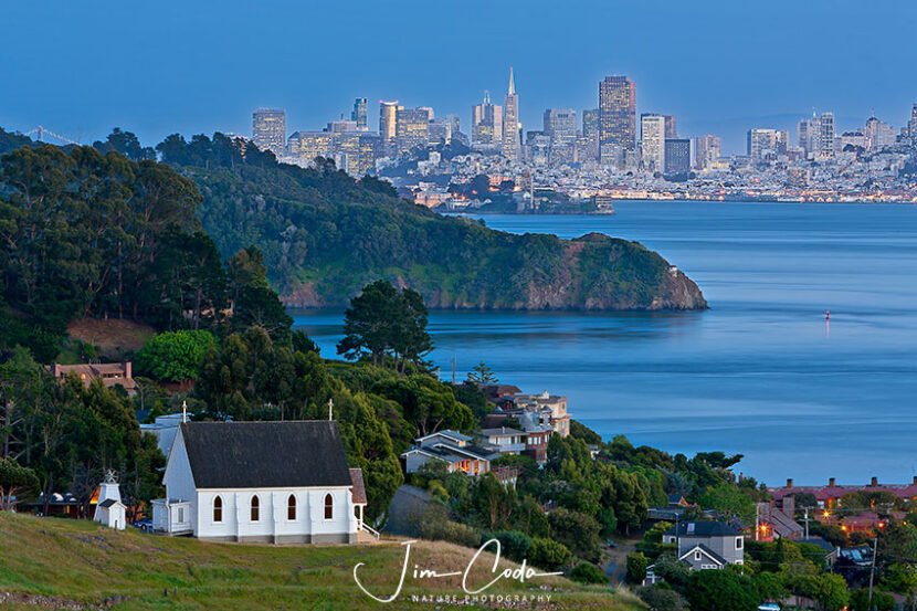 This is a photo of historic Saint Hilary's Church, Tiburon, California with Angel Island, Alcatraz, and the San Francisco Skyline in the background.