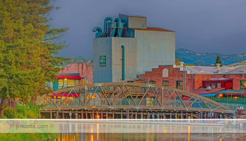 This is a photo of the pedestrian bridge and the Old Petaluma Mill on the Petaluma River.